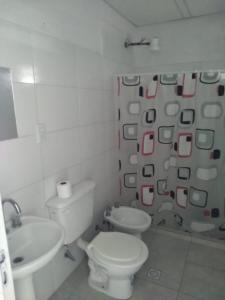 Baño blanco con aseo y lavamanos en Alojamiento Temporarios NEA en Formosa