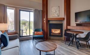 a living room with a fireplace and a couch at Estrimont in Magog-Orford