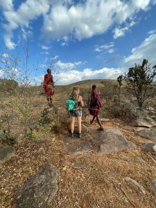 a group of people walking on a rocky trail at Lookout homestay in Sekenani