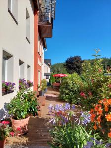 einen Garten mit Blumen auf einem hölzernen Gehweg in der Unterkunft Villa Helvetia in Bad Elster