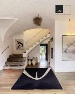 Espolla的住宿－Hotel Canaleta Heras，一间设有楼梯和黑色地毯的客厅
