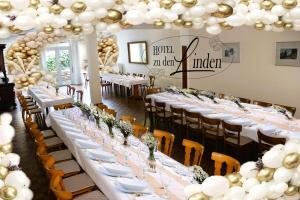 una recepción de boda con mesas blancas, sillas y globos en Hotel zu den Linden en Wachtberg