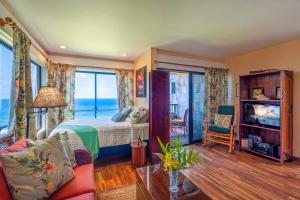a bedroom with a bed and a view of the ocean at Sealodge A6 in Princeville