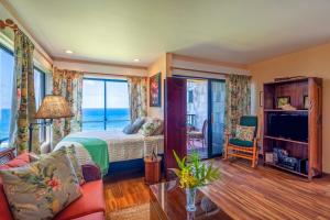 a bedroom with a bed and a view of the ocean at Sealodge A6 in Princeville