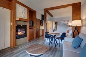 a living room with a couch and a table and a fireplace at Estrimont in Magog-Orford +35 photos
