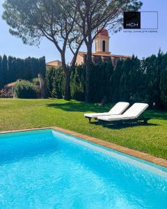 einen Pool mit zwei Liegestühlen und ein Haus in der Unterkunft Hotel Canaleta Heras in Espolla