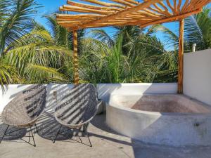 2 chaises assises devant un bain à remous dans l'établissement Hotel Boutique Can Cocal El Cuyo, à El Cuyo