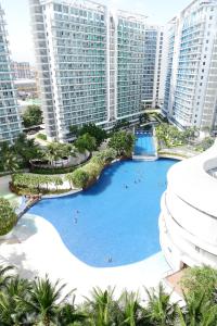 a large pool in the middle of a city with tall buildings at Azure Urban Beach Resort by Melrose Avenue in Manila