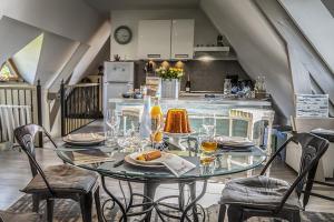 einen Glastisch mit Stühlen und eine Küche in einem Zimmer in der Unterkunft La longère en Baie - au calme sur Saint Valery pour 4 in Saint-Valery-sur-Somme
