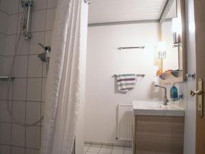 a bathroom with a shower curtain and a sink at Apartments home Atlanta Pellworm - DNS10029-CYA in Waldhusen