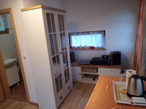 a kitchen with a glass cabinet next to a table at Nebesa so tudi na zemlji in Tomaž pri Ormožu