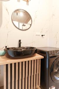 a sink on a counter next to a washing machine at Osada Joniec in Joniec