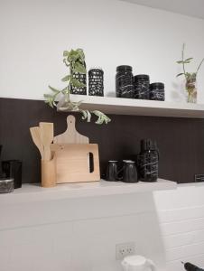 a kitchen shelf with a wooden spatula and other items at Paisaje 1 in Comodoro Rivadavia
