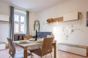 a dining room and living room with a table and chairs at [Burlo Garofalo] Modern Apartment *Wifi+Netflix* in Trieste