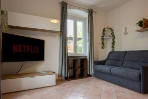 a living room with a blue couch and a tv at [Burlo Garofalo] Modern Apartment *Wifi+Netflix* in Trieste