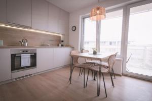 Nový štýlový byt, blízko letiska في براتيسلافا: مطبخ مع طاولة وكراسي في غرفة