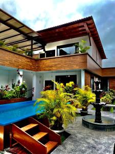 Toucan Platinum Suites Aparthotel في ميندو: بيت فيه مسبح وبعض النباتات