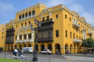 un bâtiment jaune avec des voitures garées devant lui dans l'établissement Most Central Place in Lima, à Lima