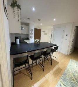 uma cozinha com uma mesa preta e cadeiras pretas em Modern 2 Bedroom Flat TH132 em Basildon