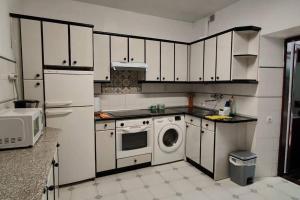 een keuken met witte kasten en een wasmachine bij Apartamento en el casco viejo de Castro Urdiales in Castro-Urdiales