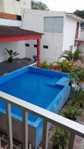 een blauw zwembad op het dak van een huis bij HOTEL LA CORDIALIDAD in Barranquilla