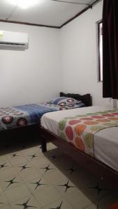 a bedroom with two beds and a window and a floor at HOTEL LA CORDIALIDAD in Barranquilla