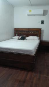a bedroom with a large bed with white sheets at HOTEL LA CORDIALIDAD in Barranquilla