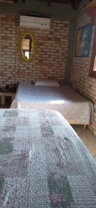 a bedroom with two beds and a mirror on the wall at Casa da Barra da Ibiraquera in Imbituba