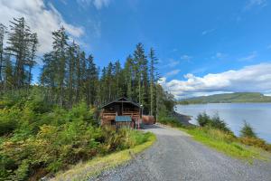 une maison sur le côté d'une route à côté d'un lac dans l'établissement Whale Pass Adventure Property, 