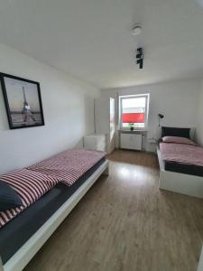 1 dormitorio con 2 camas y 2 ventanas en Ferienwohnung Haunsheim, en Haunsheim