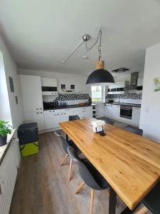 a large kitchen with a wooden table and chairs at Ferienwohnung Haunsheim in Haunsheim +3 photos