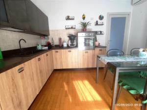 a kitchen with wooden cabinets and a wooden floor at Tuscan Gallery House in Grosseto