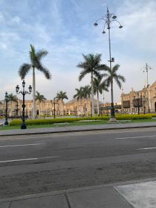 an empty street with palm trees in front of a building at Most Central Place in Lima in Lima