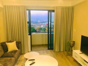 a living room with a couch and a large window at Luxury 1-bedroom Apartment With DSTV and Wi-Fi in Pretoria