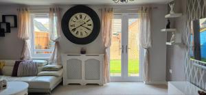 una sala de estar con un reloj grande en la pared en Entire home in Cheswick Village, en Bristol