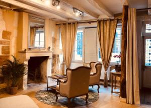 ブールジュにあるL’AMANTINE Chambres d’hôtes et gîteのリビングルーム(椅子2脚、暖炉付)