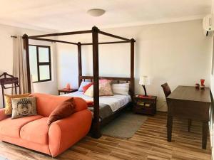 華維斯灣的住宿－Namibia Coastal Retreat，一间卧室配有四柱床和沙发