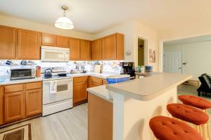 a kitchen with wooden cabinets and a counter top at Havelock Townhome with Patio about 8 Miles to River in Havelock