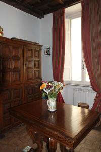 un jarrón de flores sobre una mesa de madera con una ventana en Campo dei Fiori Jewel, en Roma