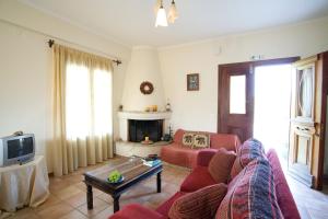 a living room with a red couch and a fireplace at Villa Simeoni in Lefkada
