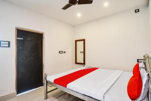 a bedroom with a bed and a black door at Hotel O Mango Leaf Hotel & Restaurant in Baharampur