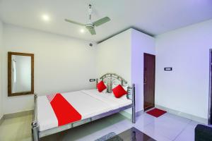a bedroom with a bed with red pillows and a mirror at OYO Flagship Mango Leaf Hotel & Restaurant in Baharampur