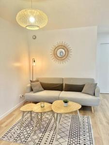 a living room with a couch and two tables at Le Ptit Bouchon - Lumineux et Calme proche commerces in Sainte-Savine