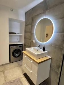 a bathroom with a sink and a washing machine at Le Ptit Bouchon - Lumineux et Calme proche commerces in Sainte-Savine