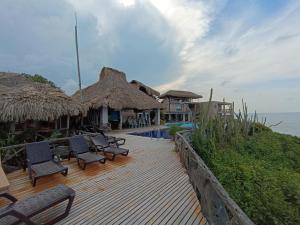 a deck with chairs and umbrellas next to the ocean at Hotel Casa Barlovento in Los Naranjos