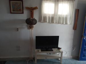 een woonkamer met een televisie en een kruis aan de muur bij El Garden in Dahab