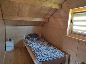 a room with a bed in a wooden cabin at Domek u Emi in Wilkasy