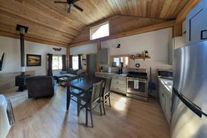 cocina y sala de estar con mesa y nevera en Whale Pass Adventure Cabin, 