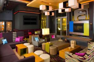 a hotel lobby with colorful furniture and a tv at aloft Green Bay in Green Bay