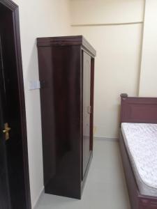 sypialnia z drewnianą szafką obok łóżka w obiekcie شقق الاحلام الذهبية 